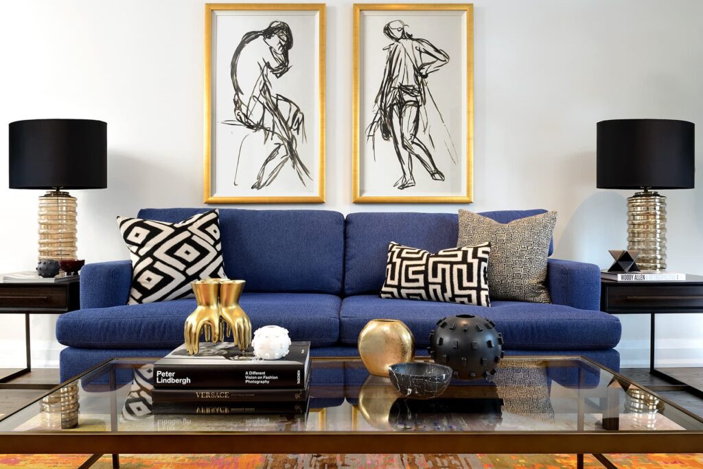 Living room with blue sofa and graphic black and white pillows and art