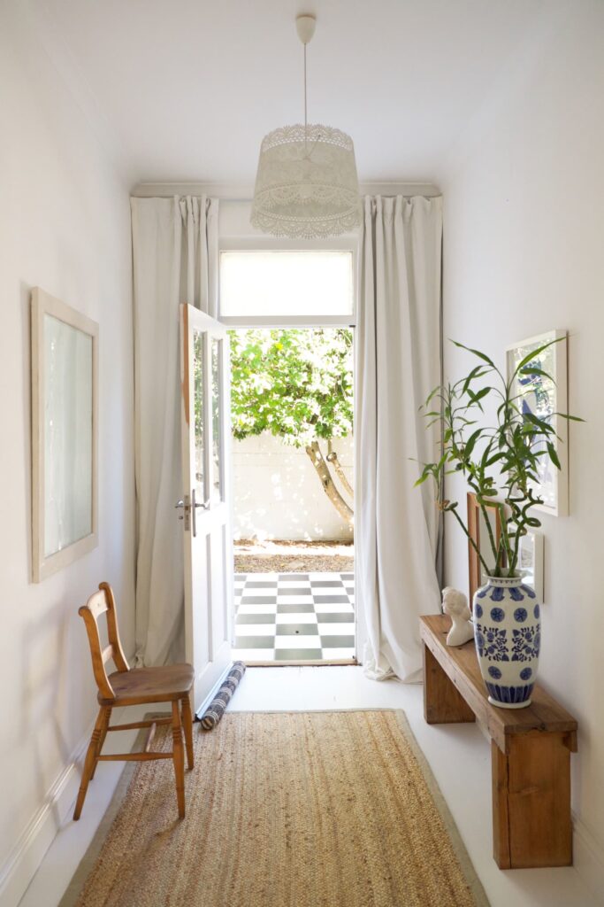 Picture of doorway to outside with drapery on each side of door pooling at the floor